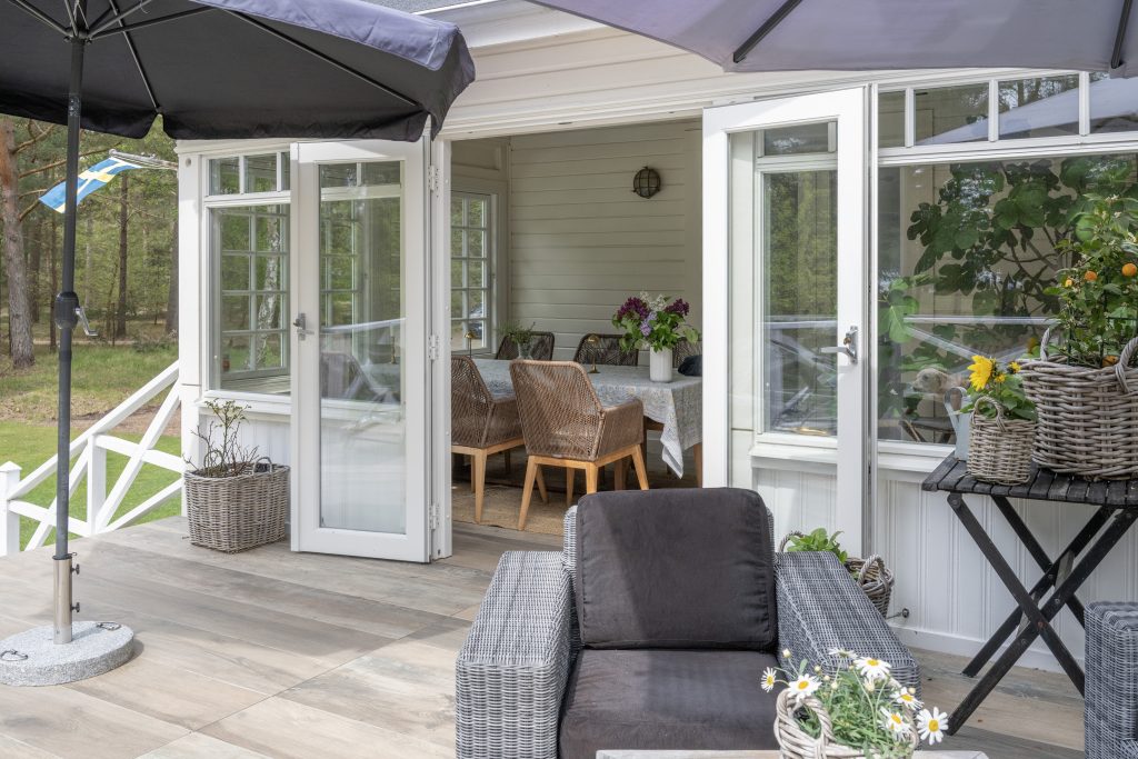 Outdoor terrace connected to indoor dining area in a modern villa in Höllviken, South Sweden